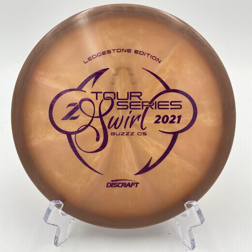 Top view of vibrant Z Swirl Discraft Buzzz OS in durable plastic - 2021 Ledgestone Tour Series with stunning artwork.