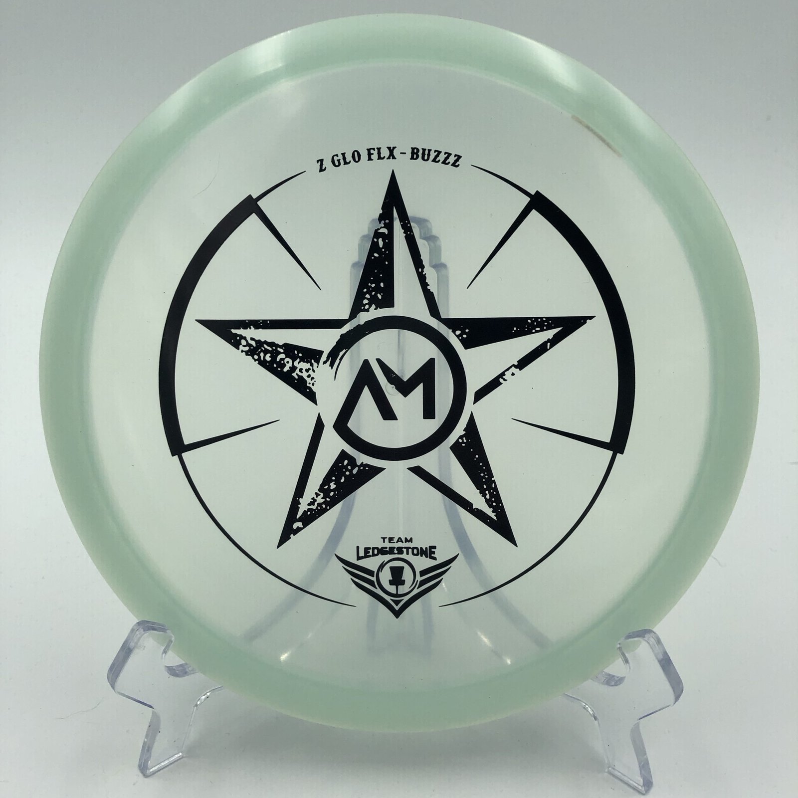 Top view of glowing green Discraft Z Glo FLX Buzzz in Ledgestone plastic with special edition stamp.