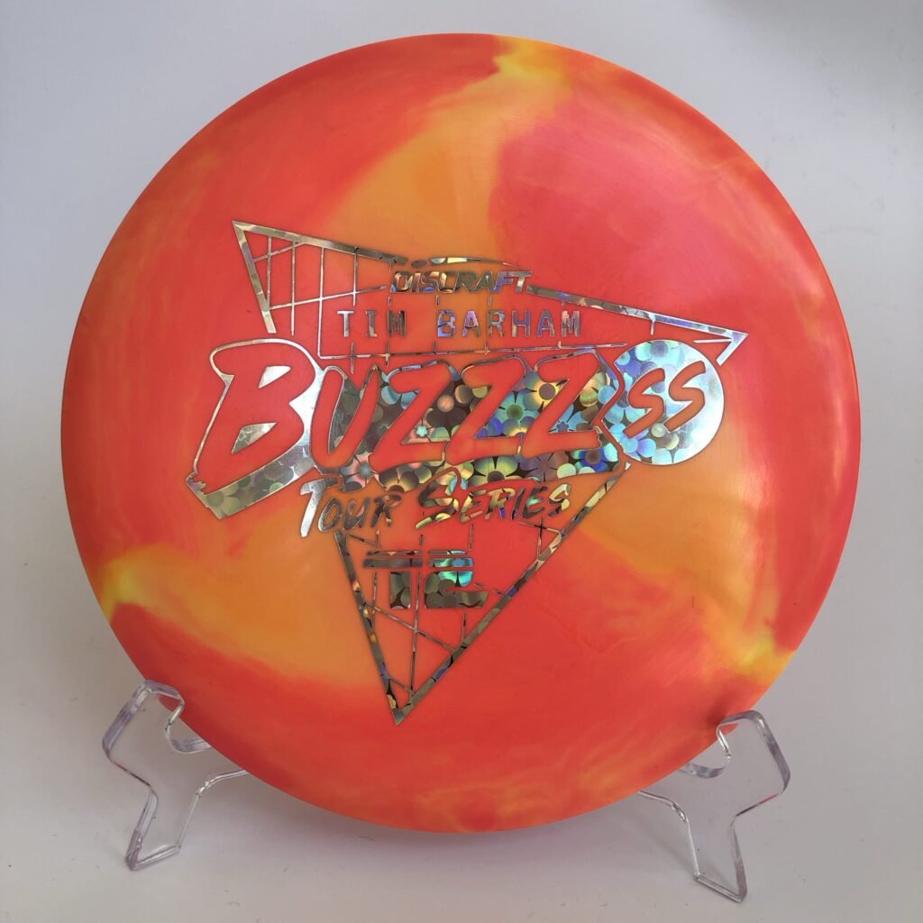 Top view of vibrant ESP swirl Discraft Buzzz SS - 2022 Tour Series with Tim Barham's signature.