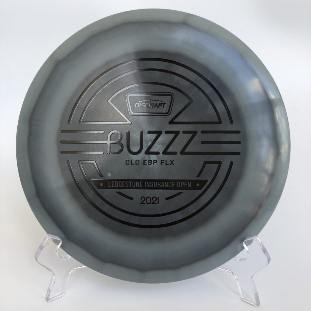 Top view of glowing green Discraft ESP FLX Buzzz in Ledgestone 2021 Edition with a vibrant stamp.