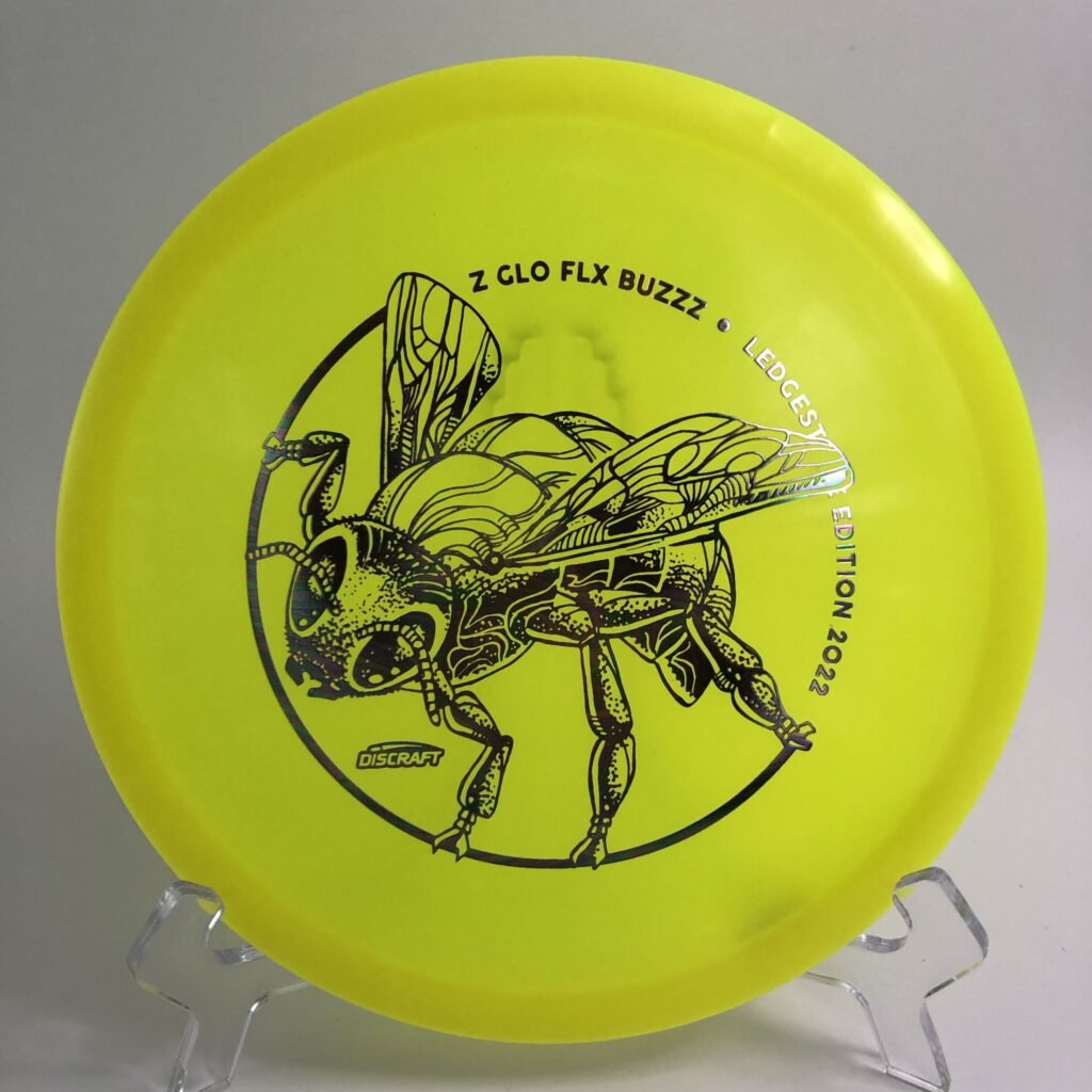 Top view of glow-in-the-dark green Discraft Buzzz in Z Glo FLX plastic 2022 Ledgestone Edition with vibrant foil stamp.