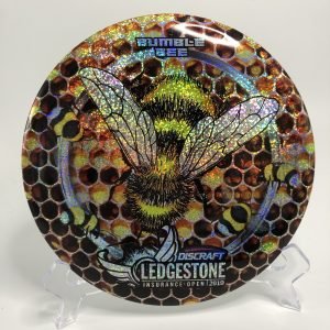 Top view of black and yellow Discraft Buzzz in ESP plastic - 2019 Ledgestone Incurance Open with special foil stamp.