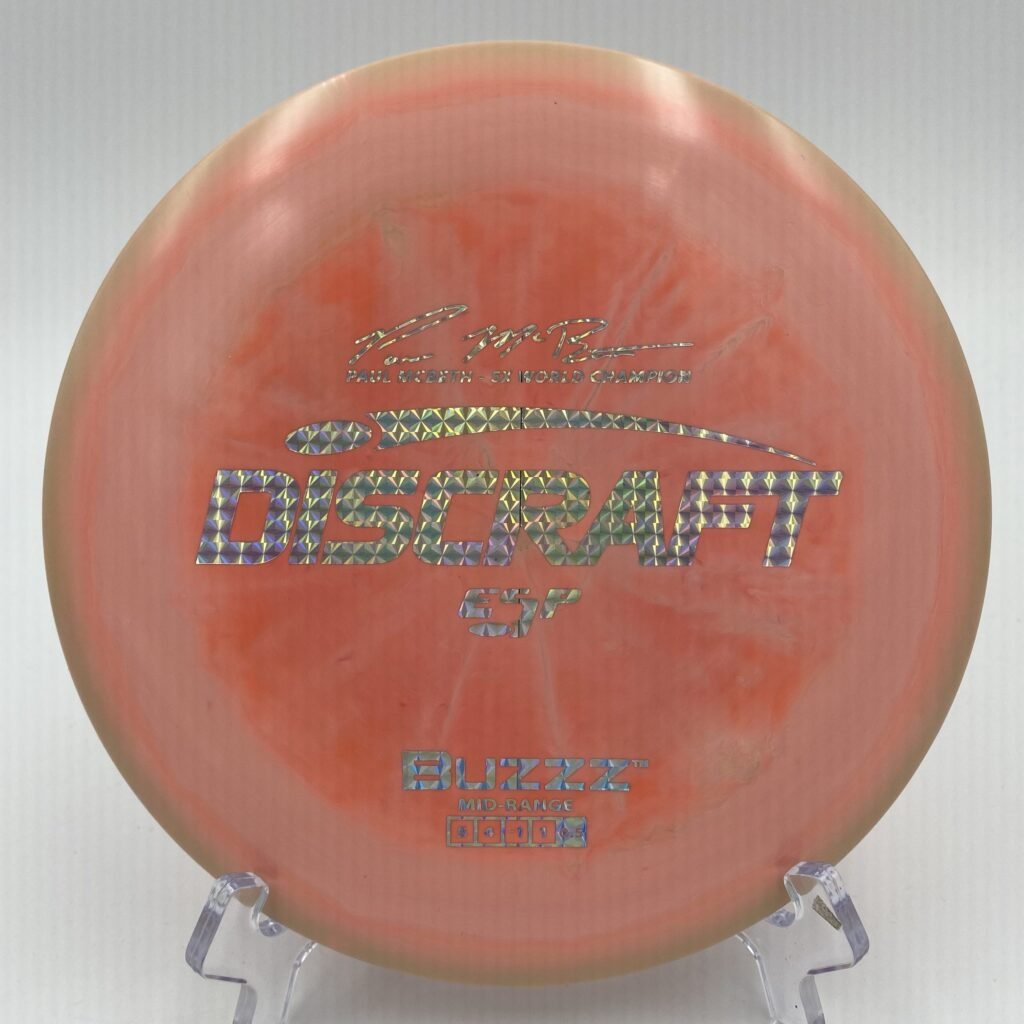 Top view of swirly multicolor Discraft Buzzz in ESP plastic - Paul McBeth 5x edition for maximum stability.